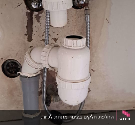 צנרת פלסטיק מתחת לכיור עם חיבורים